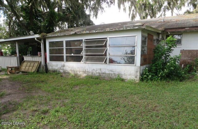 view of side of home with a yard