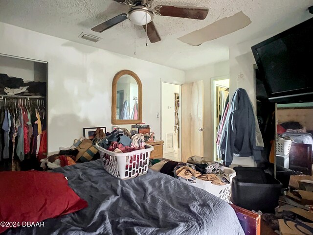 bedroom featuring ceiling fan, a textured ceiling, and a closet