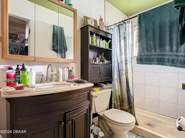 bathroom featuring toilet, vanity, tile patterned floors, and walk in shower