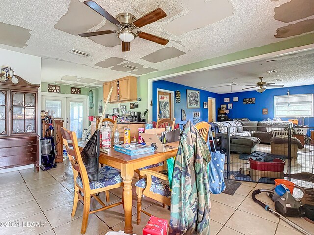 tiled dining area with french doors, a textured ceiling, and ceiling fan