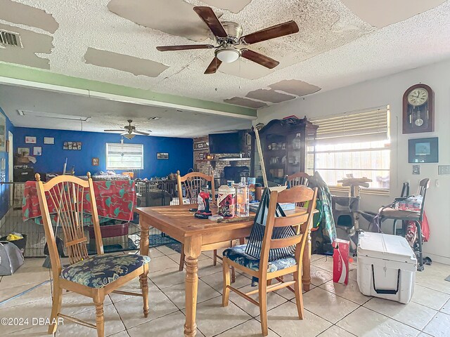 dining room featuring a textured ceiling, tile patterned flooring, and ceiling fan