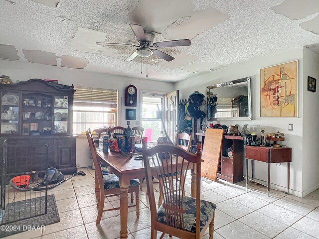 tiled dining area featuring a textured ceiling and ceiling fan