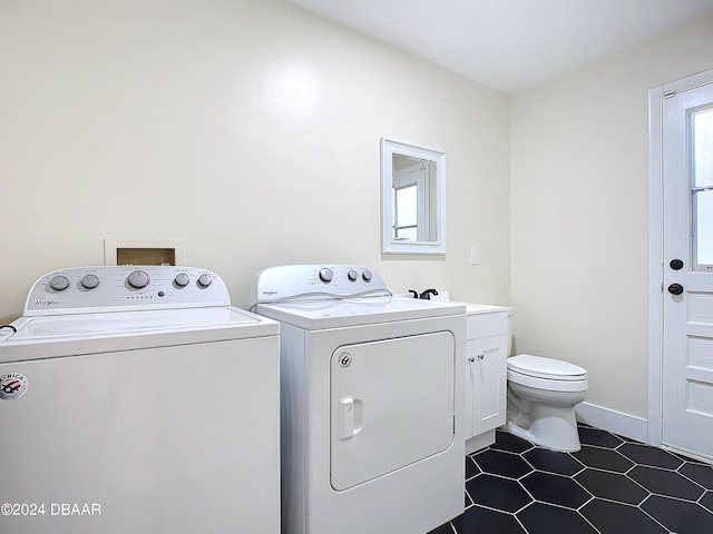 clothes washing area featuring dark tile patterned flooring and independent washer and dryer