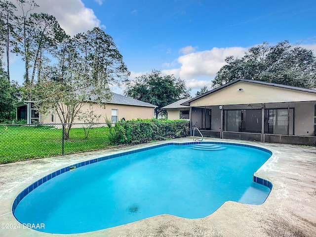 view of pool with a sunroom and a yard