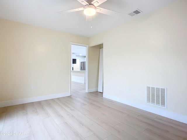 empty room with ceiling fan and light hardwood / wood-style flooring