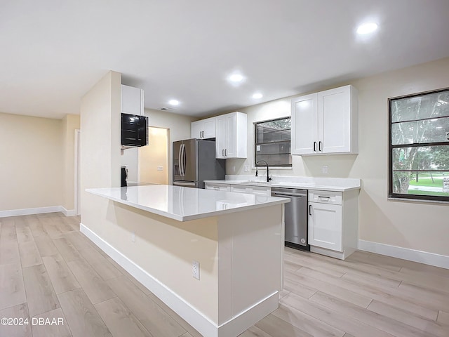 kitchen featuring white cabinetry, stainless steel appliances, and light hardwood / wood-style flooring