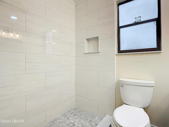 bathroom featuring toilet and tiled shower