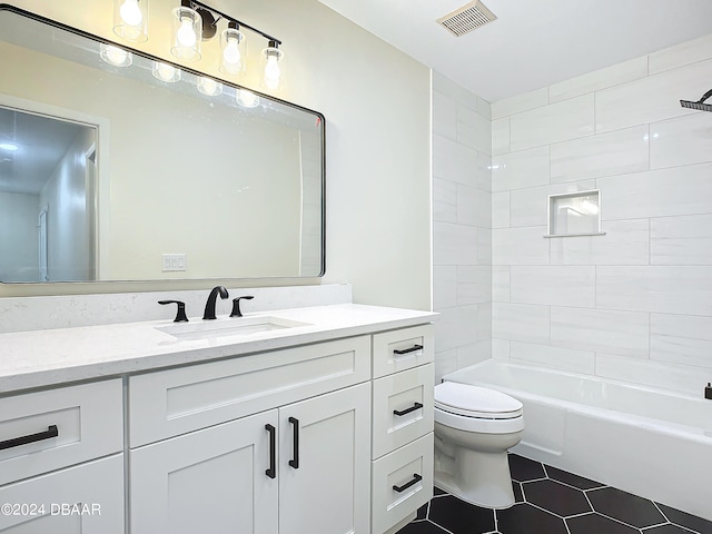 full bathroom featuring toilet, vanity, tiled shower / bath, and tile patterned floors