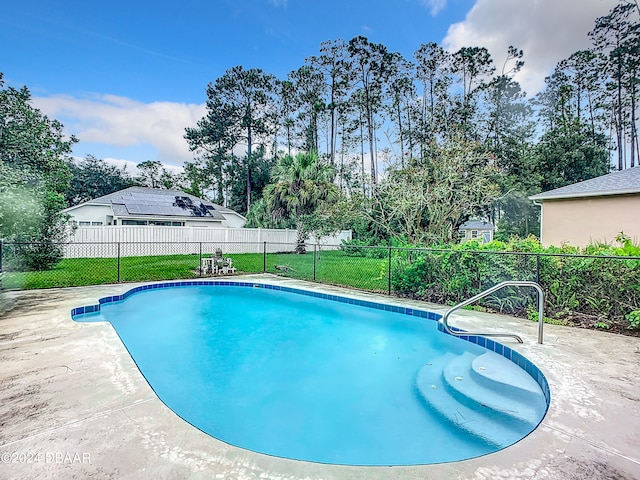 view of pool featuring a patio and a yard