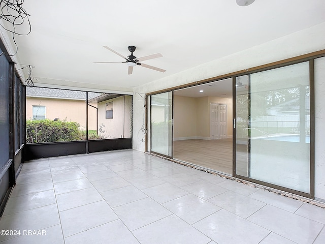 unfurnished sunroom with ceiling fan