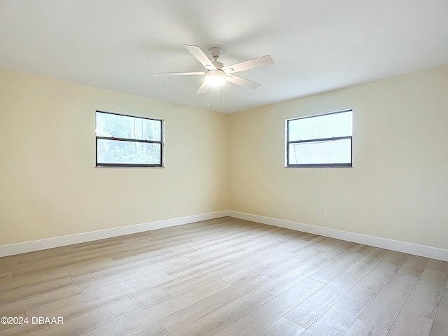 unfurnished room featuring a wealth of natural light, ceiling fan, and light hardwood / wood-style flooring