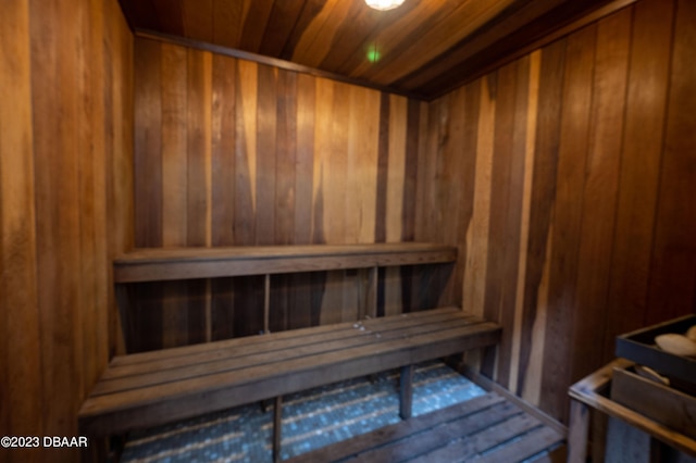 view of sauna with wooden ceiling and wood walls