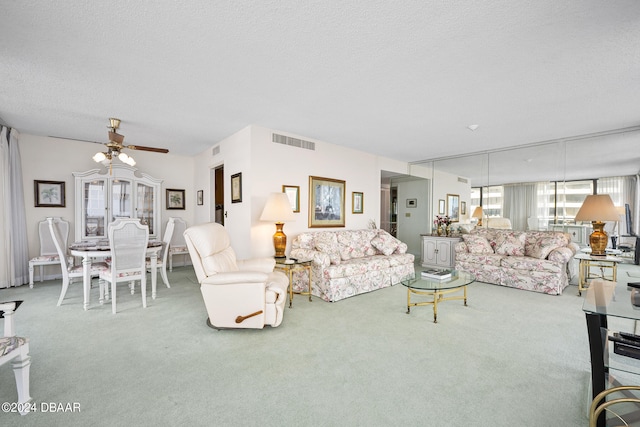 living room with carpet flooring, a textured ceiling, and ceiling fan