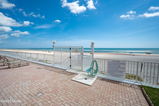 view of patio with a water view and a view of the beach