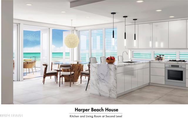 kitchen featuring white cabinetry, a water view, light stone counters, hanging light fixtures, and oven