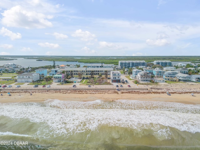 drone / aerial view featuring a beach view and a water view