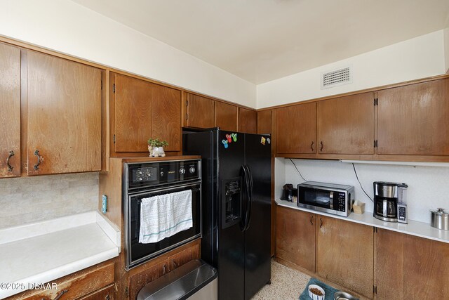 4245 Cardinal Blvd, Port Orange, FL 32127 - kitchen featuring visible vents, light countertops, brown cabinets, and black appliances