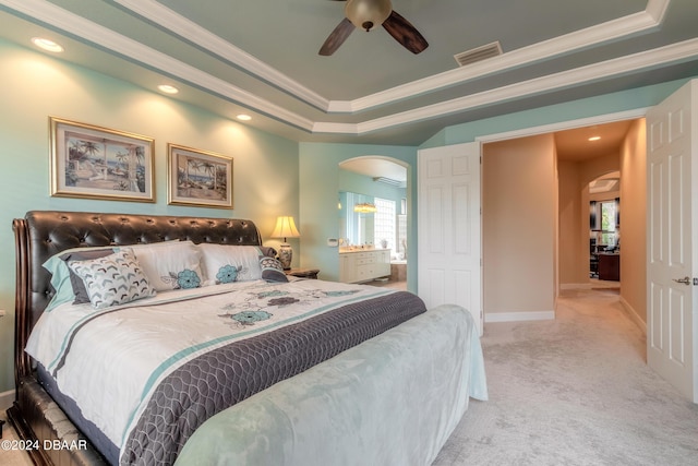 bedroom with a tray ceiling, ceiling fan, ornamental molding, and light colored carpet