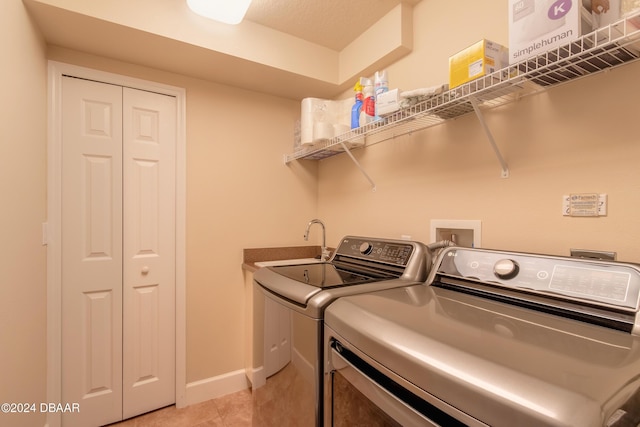 clothes washing area featuring washing machine and dryer and light tile patterned floors