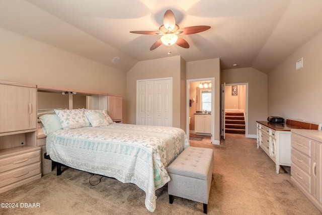 bedroom with lofted ceiling, light carpet, ensuite bath, ceiling fan, and a closet