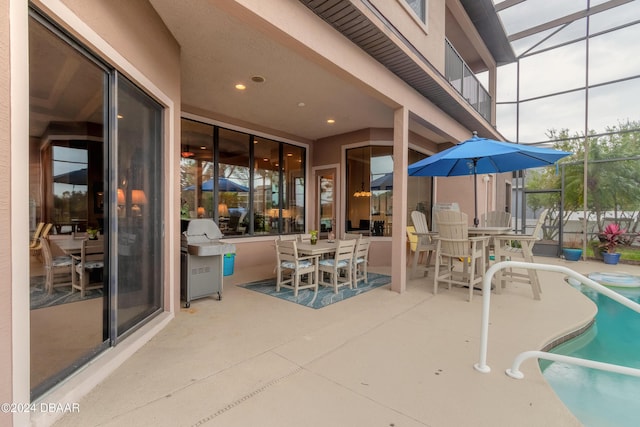 view of patio with glass enclosure and area for grilling