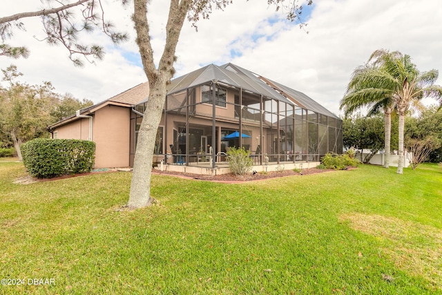 back of property with a lanai and a lawn