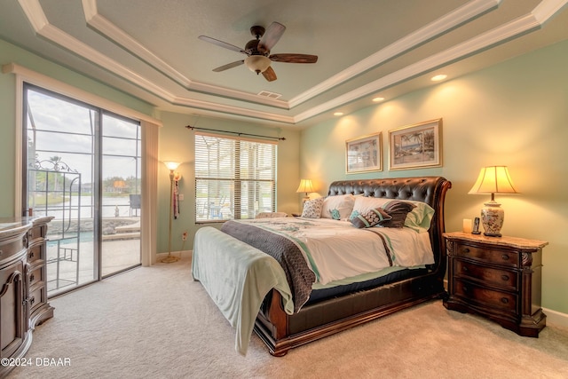 bedroom featuring ceiling fan, access to exterior, light colored carpet, and a tray ceiling