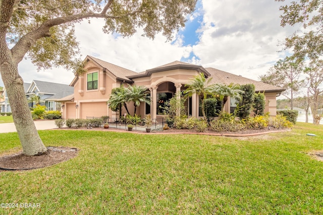 mediterranean / spanish house featuring a front yard and a garage
