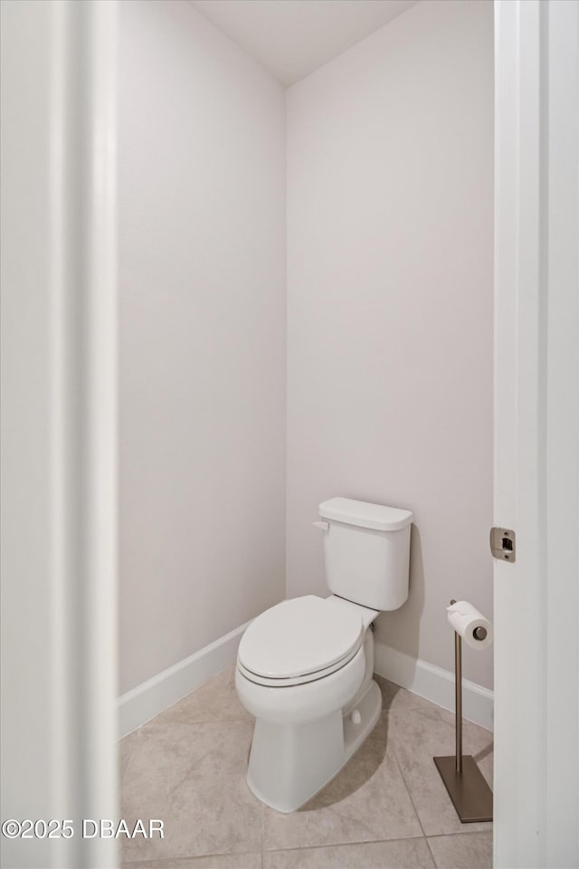 bathroom with tile patterned floors, baseboards, and toilet