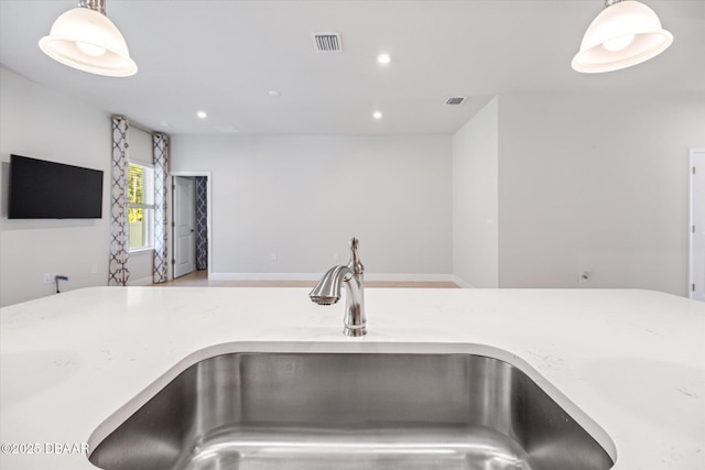 interior details featuring a sink, visible vents, recessed lighting, and hanging light fixtures