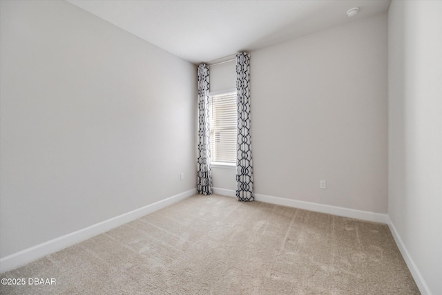 spare room featuring baseboards and carpet