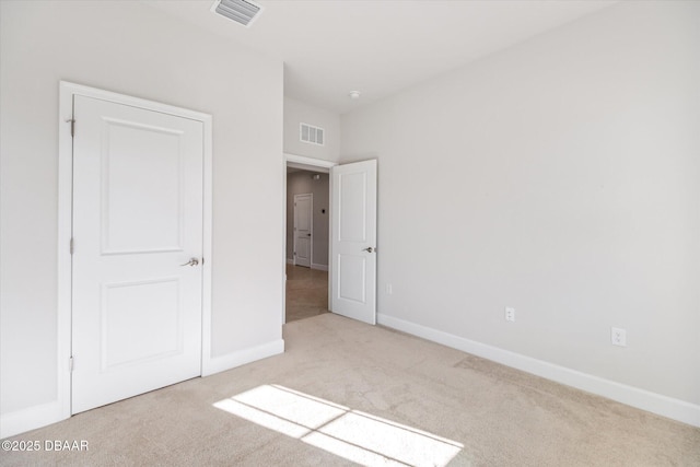 unfurnished bedroom with visible vents, baseboards, and carpet