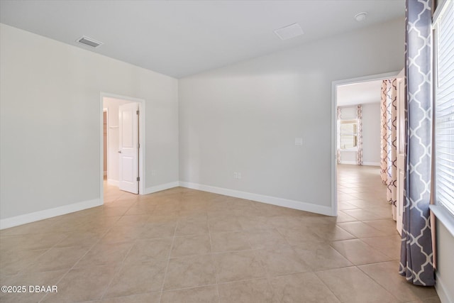 unfurnished room featuring light tile patterned floors, visible vents, and baseboards