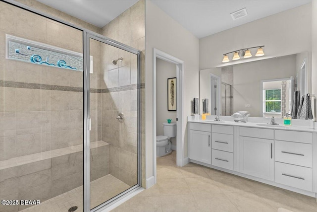 bathroom with double vanity, a stall shower, visible vents, and a sink