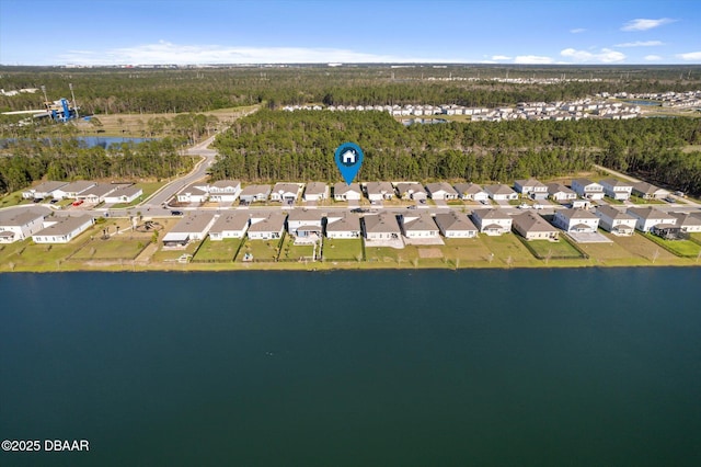 aerial view with a wooded view, a residential view, and a water view