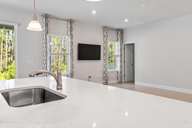 kitchen featuring recessed lighting, a healthy amount of sunlight, pendant lighting, and a sink