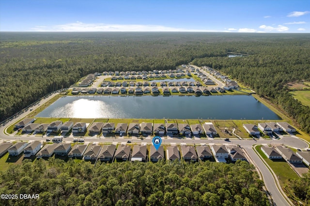 drone / aerial view featuring a view of trees, a water view, and a residential view