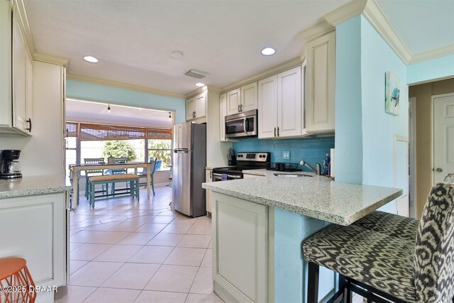 7 Azalea Dr, Ormond Beach, FL 32176 - kitchen featuring light tile patterned floors, ornamental molding, a sink, visible vents, and appliances with stainless steel finishes