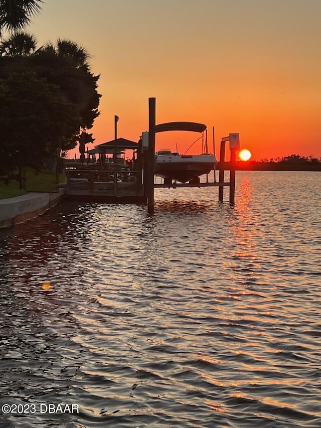 patio terrace at dusk with a water view and an outdoor hangout area