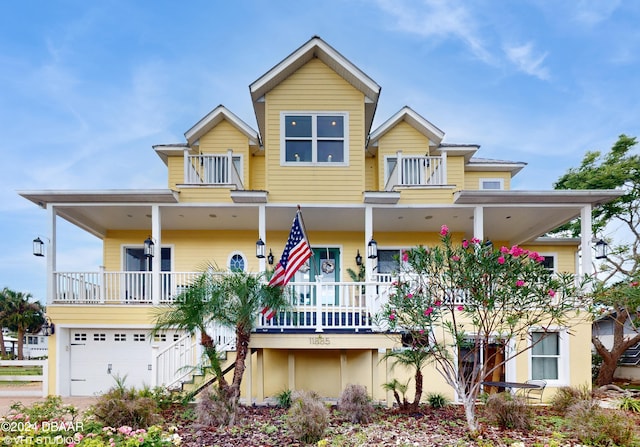 view of front facade featuring covered porch, a balcony, and a garage