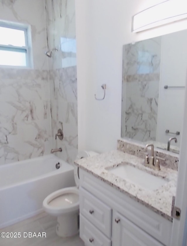 bathroom with toilet,  shower combination, and vanity