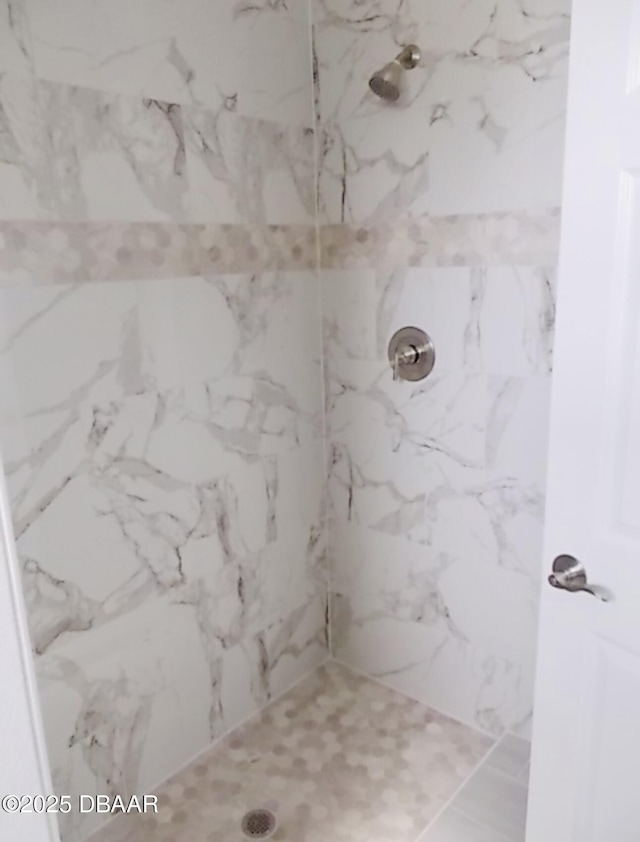 bathroom with a marble finish shower