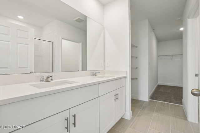 288 Links Terrace Blvd, Daytona Beach, FL 32124 - bathroom with double vanity, a walk in closet, a shower with shower door, and recessed lighting