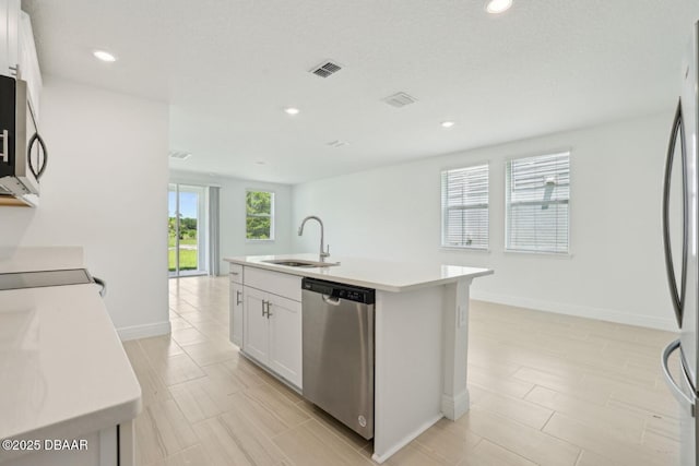 288 Links Terrace Blvd, Daytona Beach, FL 32124 - kitchen featuring stainless steel appliances, light countertops, a kitchen island with sink, white cabinetry, and recessed lighting