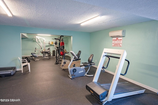 workout area with a textured ceiling and a wall mounted AC