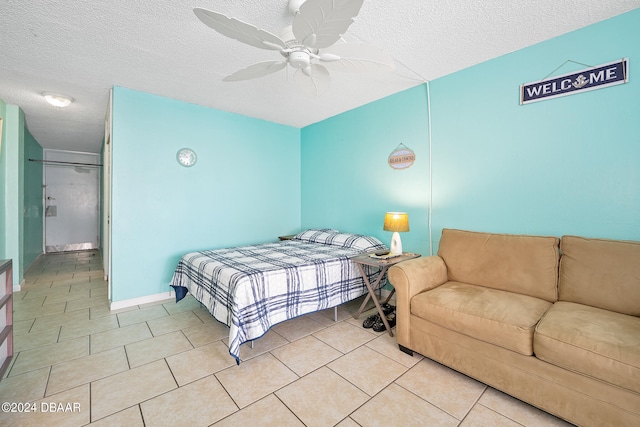 bedroom featuring a textured ceiling, light tile patterned floors, and ceiling fan