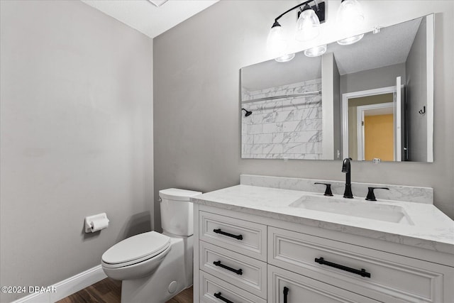 bathroom featuring walk in shower, wood-type flooring, a textured ceiling, toilet, and vanity