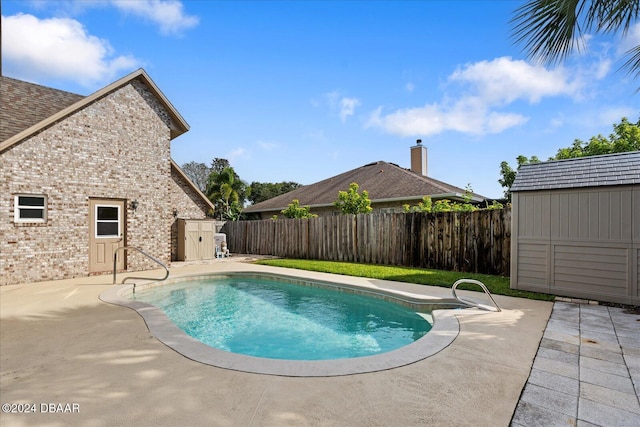 view of pool with a shed and a patio area