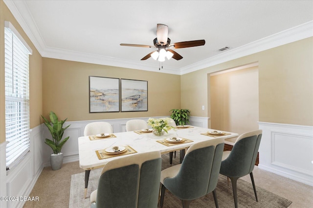 dining area with light carpet, ceiling fan, and crown molding