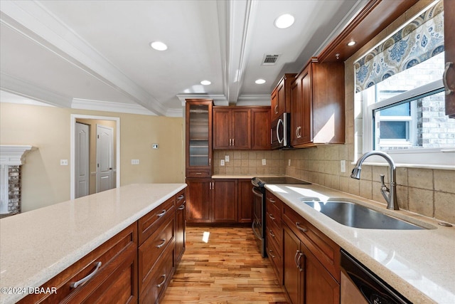 kitchen featuring decorative backsplash, ornamental molding, stainless steel appliances, sink, and light hardwood / wood-style flooring